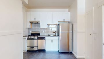 San Francisco apartment for rent - A kitchen with white cabinets and a stainless steel refrigerator.