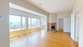 San Francisco apartment for rent - A large, empty room with a fireplace and wooden floors.