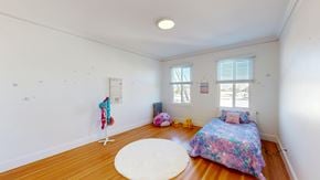 San Francisco apartment for rent - A room with a bed, a rug, a window, and a wall hanging.