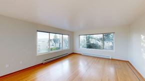 San Francisco apartment for rent - A large empty room with wooden floors and two windows.