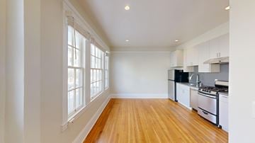 San Francisco apartment for rent - A kitchen with white cabinets and a wooden floor.