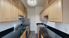 San Francisco apartment for rent - A kitchen with wooden cabinets and black countertops.