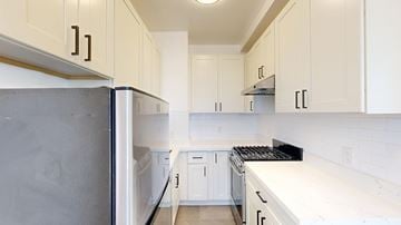 San Francisco apartment for rent - A kitchen with white cabinets and a black refrigerator.