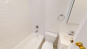 San Francisco apartment for rent - A white bathroom with a tub, toilet, and sink.