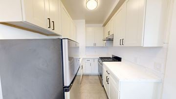 San Francisco apartment for rent - A kitchen with white cabinets and a black fridge.