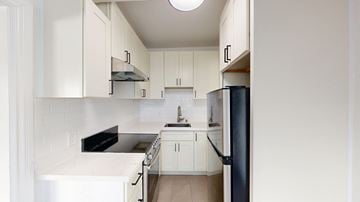 San Francisco apartment for rent - A kitchen with white cabinets and a black refrigerator.