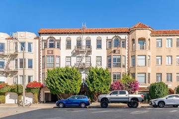 San Francisco apartment for rent - A blue car is parked in front of a building with a red tile roof.