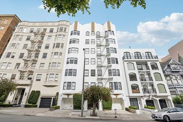 San Francisco apartment for rent - A white building with black windows and a tree in front.