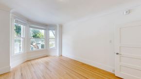 San Francisco apartment for rent - A room with a white door and a window with a view of trees.