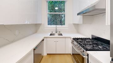 San Francisco apartment for rent - A kitchen with white cabinets and a black stove top.