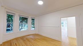 San Francisco apartment for rent - A room with white walls and wooden flooring with a window on the left.