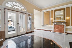 San Francisco apartment for rent - Grand entrance to a building, featuring a large archway, a fireplace, and a doormat