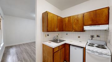 San Francisco apartment for rent - A kitchen with white appliances and wooden cabinets.