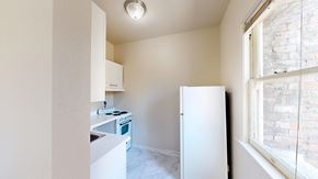 San Francisco apartment for rent - A small kitchen with a white fridge and a window.