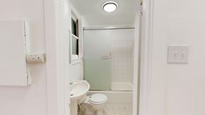 San Francisco apartment for rent - A white toilet sits in a small bathroom with a glass shower door.