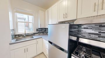 San Francisco apartment for rent - A white refrigerator is in a kitchen with white cabinets.