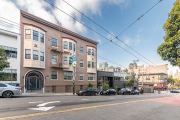 San Francisco apartment for rent - A street view of a building with cars parked in front.