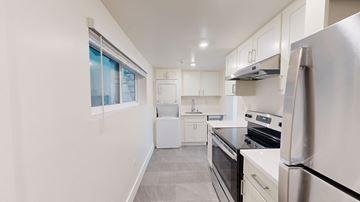 San Francisco apartment for rent - A modern kitchen with stainless steel appliances and white cabinetry.