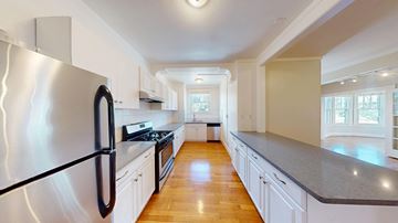 San Francisco apartment for rent - A modern kitchen with a black refrigerator and wooden floors.