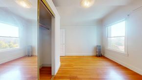 San Francisco apartment for rent - A room with wooden floors and white walls, with a door on the left side.