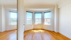 San Francisco apartment for rent - A room with wooden floors and three windows.