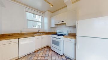 San Francisco apartment for rent - A kitchen with white appliances and brown tiles.
