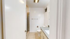 San Francisco apartment for rent - A white bathroom with a toilet, sink, and mirror.