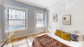 San Francisco apartment for rent - A bedroom with a bed, a chair, and two pictures on the wall.