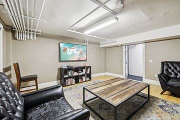 San Francisco apartment for rent - A living room with a black leather chair, a wooden coffee table, and a painting on the wall.