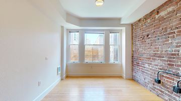 San Francisco apartment for rent - A room with a brick wall and a window with a view of a balcony.