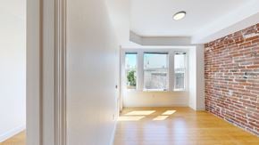 San Francisco apartment for rent - A room with a brick wall and wooden flooring.
