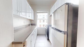 San Francisco apartment for rent - A kitchen with white cabinets and a stainless steel refrigerator.