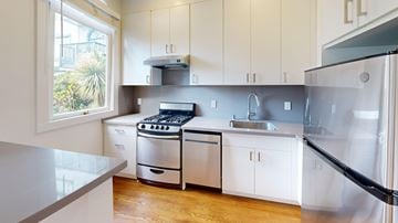 San Francisco apartment for rent - A modern kitchen with white cabinets and stainless steel appliances.