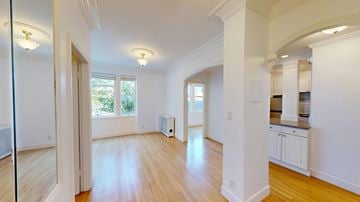San Francisco apartment for rent - A spacious room with wooden floors and white walls.