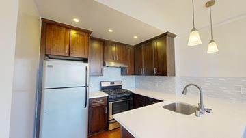 San Francisco apartment for rent - A kitchen with a white counter top and wooden cabinets.