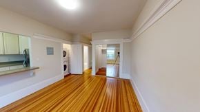 San Francisco apartment for rent - A long hallway with wood floors and white walls.