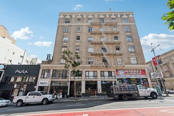 San Francisco apartment for rent - A white truck is parked in front of a building with a red awning.