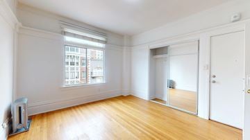 San Francisco apartment for rent - A room with a large window and wooden floors.