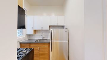 San Francisco apartment for rent - A kitchen with a stove top oven, refrigerator, and cabinets.