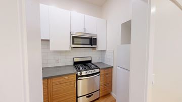 San Francisco apartment for rent - A kitchen with white cabinets and a stainless steel stove.