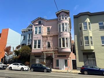 San Francisco apartment for rent - A row of three colorful houses with cars parked in front.