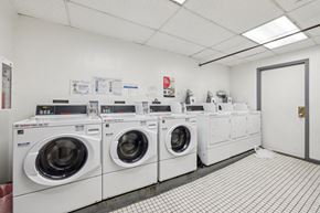 San Francisco apartment for rent - Laundry room with commercial washers and dryers, tiled floor, and posted instructions