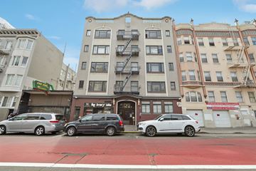 San Francisco apartment for rent - A street view of a city with cars parked and buildings in the background.
