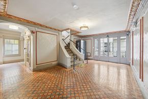 San Francisco apartment for rent - Hallway is illuminated by a chandelier hanging from the ceiling, and a window on the far left side allows natural light to enter the room