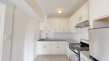 San Francisco apartment for rent - A kitchen with white cabinets and a stainless steel refrigerator.