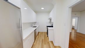 San Francisco apartment for rent - A kitchen with white cabinets and a black counter.
