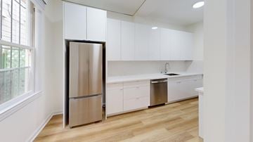 San Francisco apartment for rent - A modern kitchen with a stainless steel refrigerator and white cabinets.