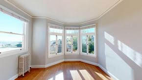 San Francisco apartment for rent - A sunny room with a wood floor and a white wall.