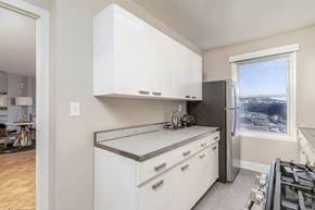 San Francisco townhouse for rent - A kitchen with white cabinets and a window overlooking a cityscape.