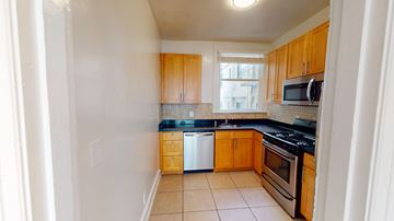 San Francisco apartment for rent - A kitchen with wooden cabinets and a tiled backsplash.